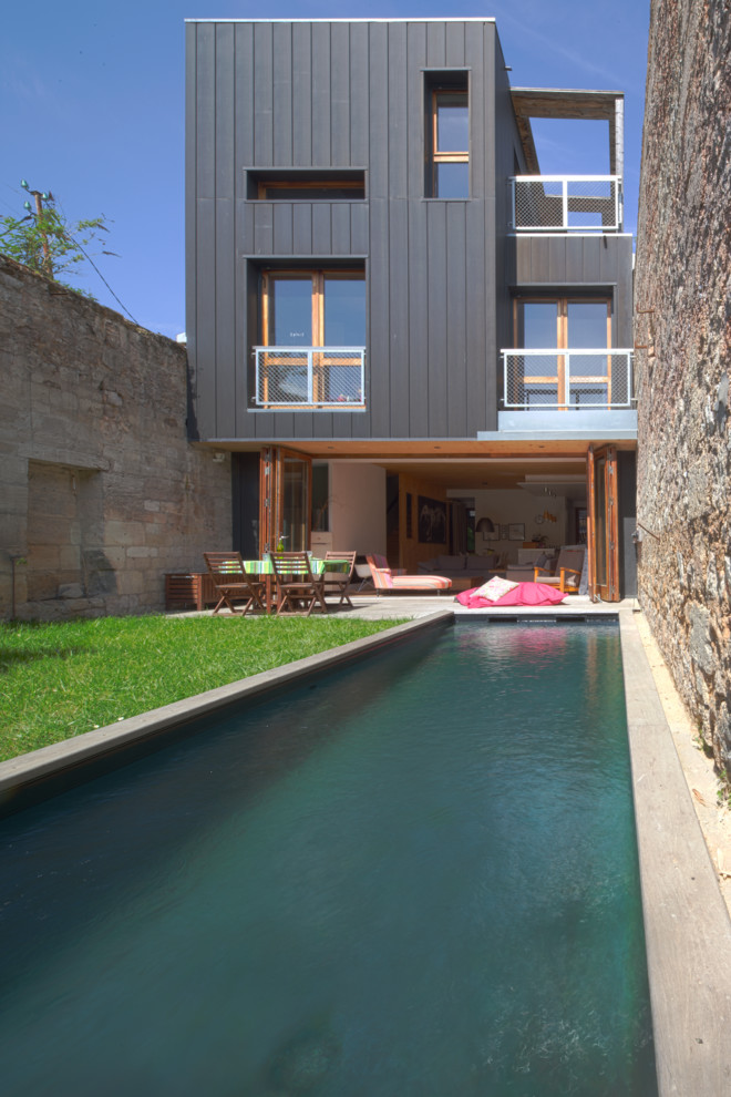 Réalisation d'un petit couloir de nage arrière design rectangle avec une terrasse en bois.