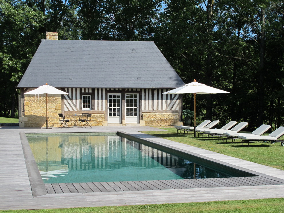 Idée de décoration pour une piscine tradition de taille moyenne et rectangle avec une terrasse en bois.