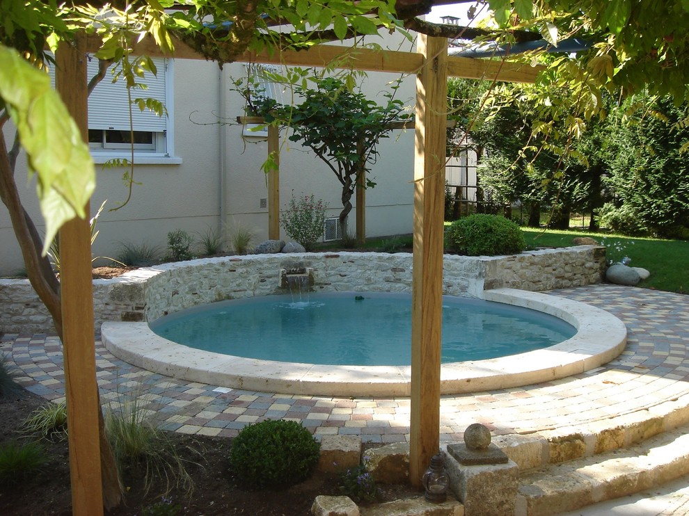 Imagen de piscina actual pequeña redondeada en patio