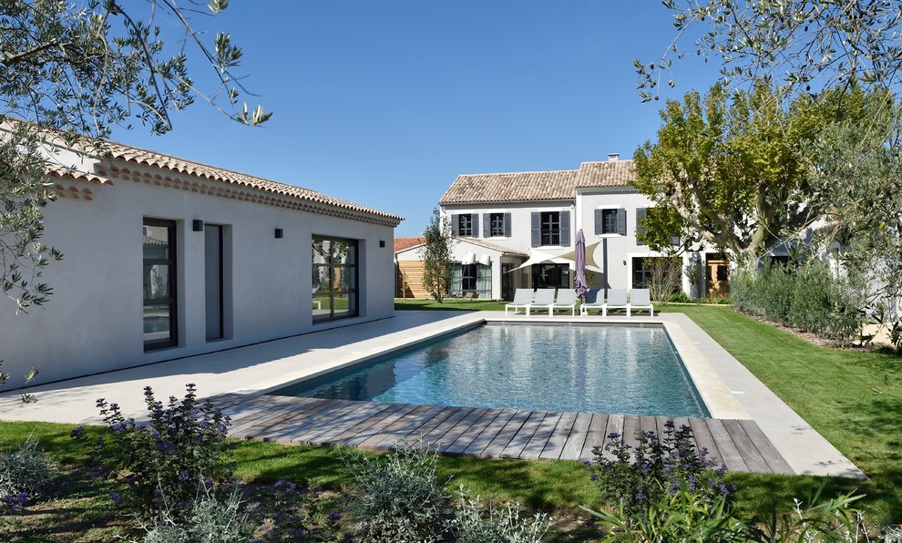 Foto di una grande piscina monocorsia minimal rettangolare davanti casa con pavimentazioni in pietra naturale