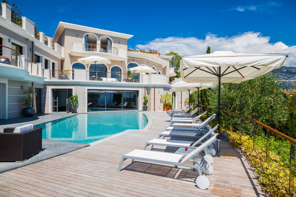 Exemple d'une piscine méditerranéenne avec une terrasse en bois.