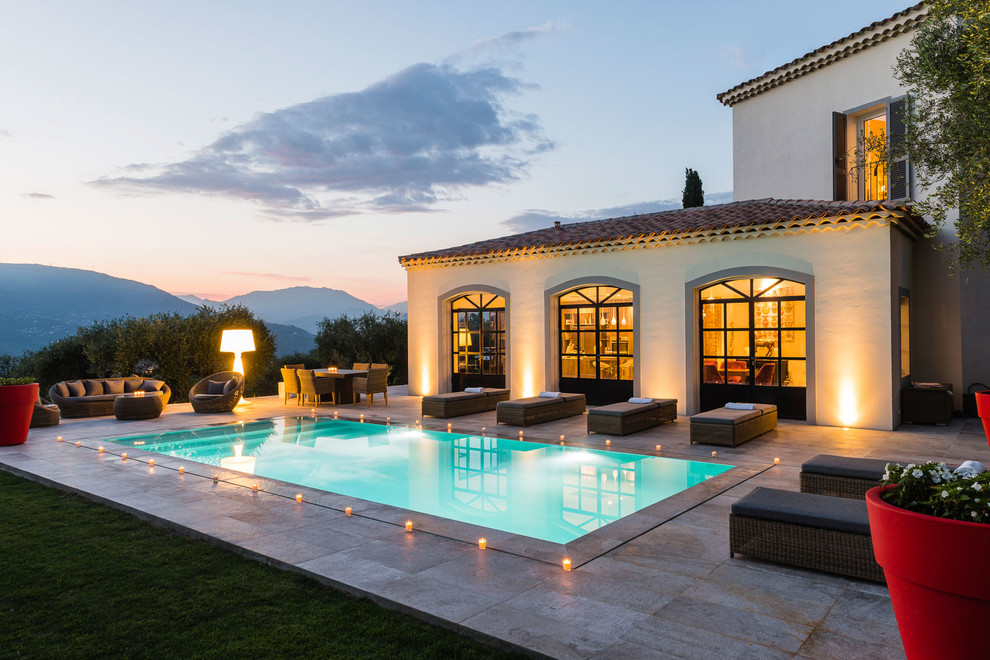 На фото: прямоугольный бассейн на заднем дворе в средиземноморском стиле с покрытием из плитки