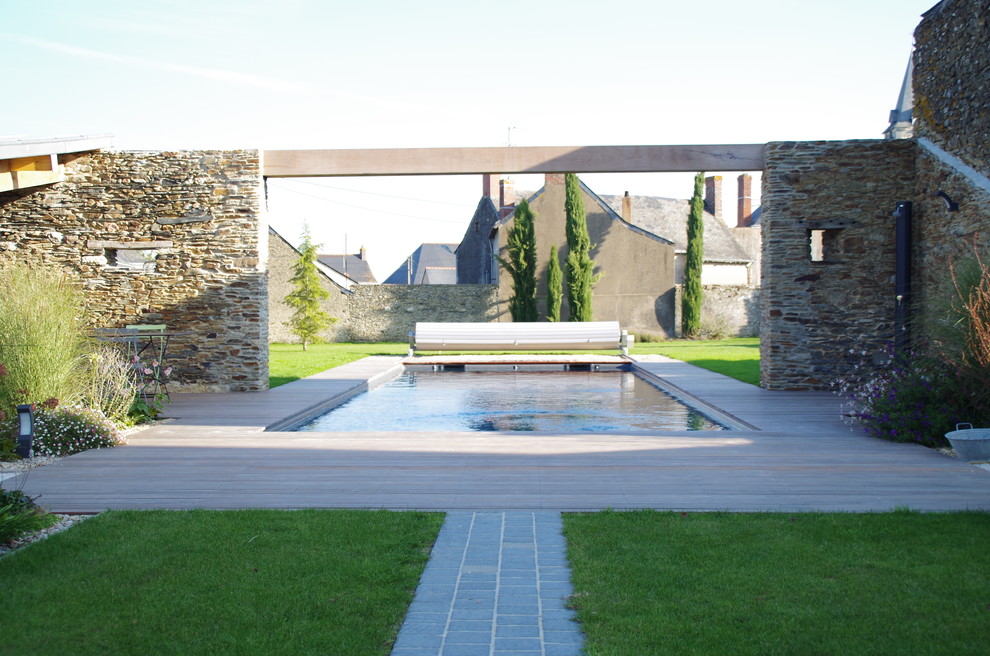 Foto de piscina alargada mediterránea grande rectangular en patio trasero con entablado