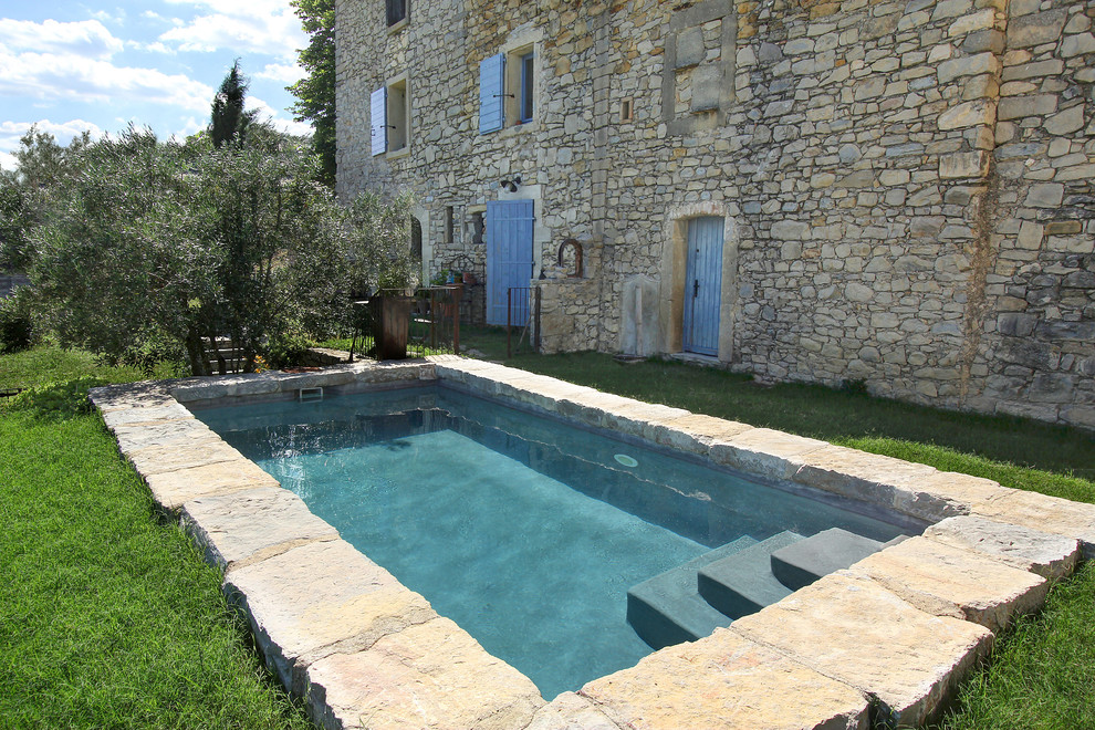 Immagine di una piccola piscina tradizionale rettangolare con pavimentazioni in pietra naturale