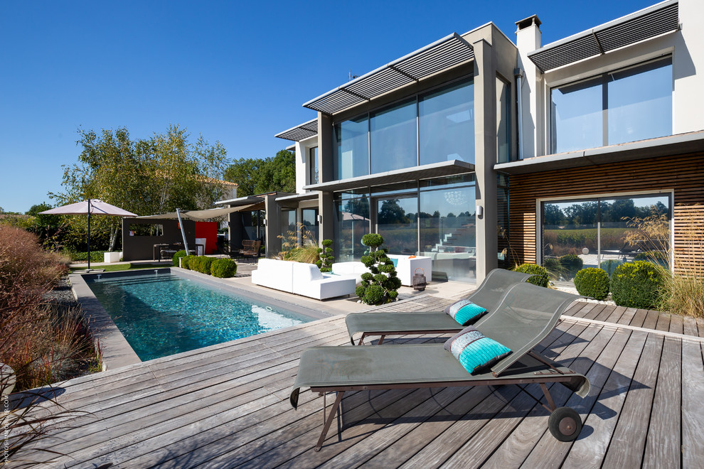 Idées déco pour un couloir de nage arrière classique rectangle avec une terrasse en bois.