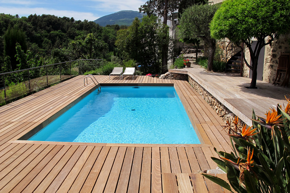 Пример оригинального дизайна: прямоугольный, спортивный бассейн среднего размера в средиземноморском стиле с настилом