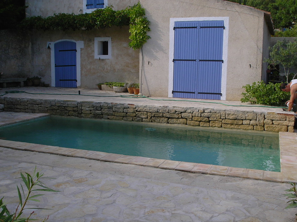 Bild på en liten medelhavsstil pool, med vattenrutschkana