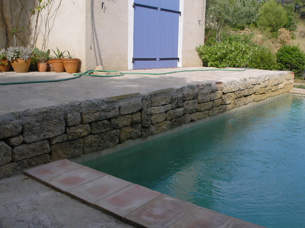 Diseño de piscina con tobogán mediterránea pequeña