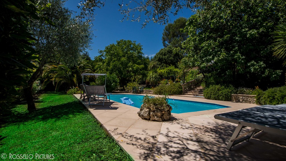 Foto de piscina mediterránea extra grande rectangular en patio delantero con suelo de baldosas