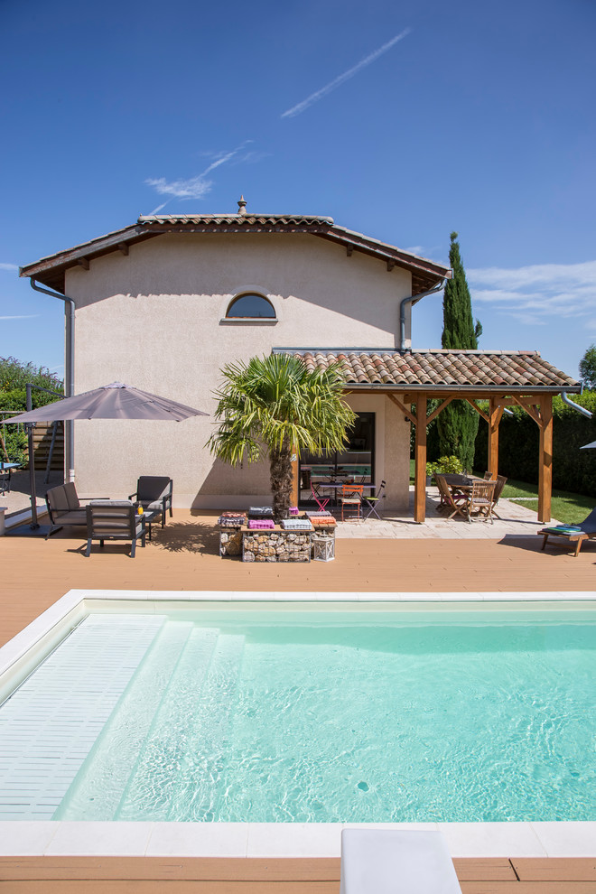 Idées déco pour une grande piscine méditerranéenne rectangle avec une terrasse en bois.