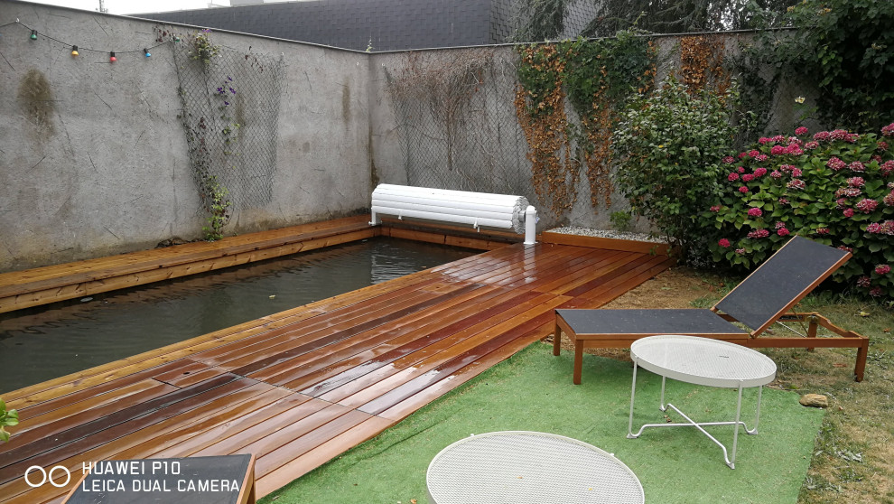 Modelo de piscina natural clásica renovada de tamaño medio rectangular en patio con entablado