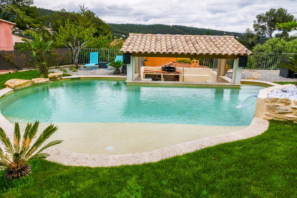Medium sized contemporary custom shaped swimming pool in Marseille with a water feature.