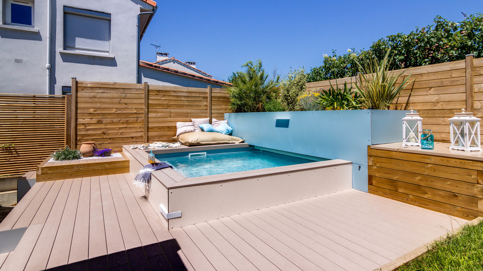 Inspiration pour une petite piscine hors-sol design sur mesure avec une terrasse en bois.
