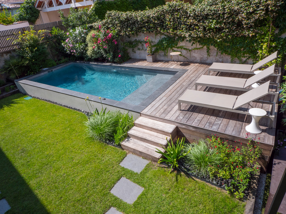 Imagen de piscina elevada actual de tamaño medio rectangular en patio con entablado