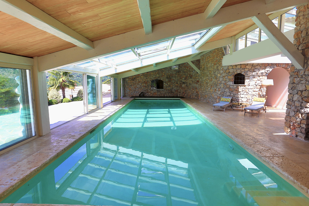 Large traditional indoor rectangular lengths swimming pool with natural stone paving.