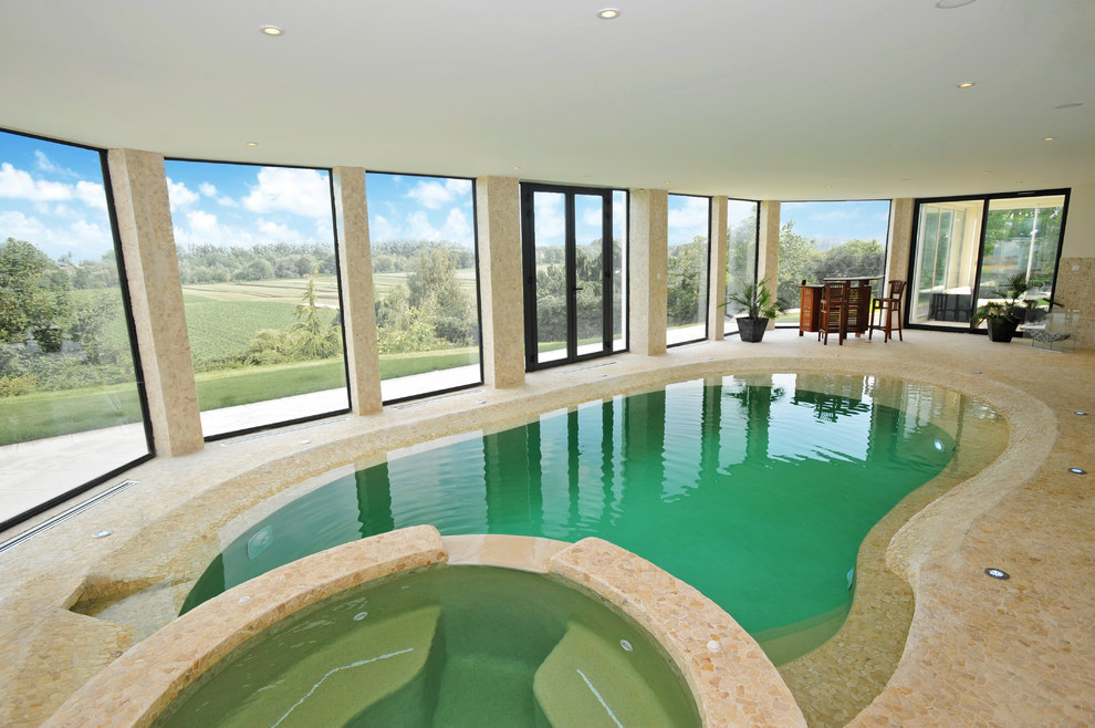 Пример оригинального дизайна: бассейн среднего размера, в форме фасоли в доме в средиземноморском стиле с джакузи и покрытием из каменной брусчатки