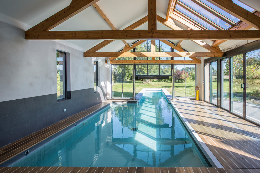 На фото: спортивный бассейн среднего размера в доме в стиле модернизм с домиком у бассейна с