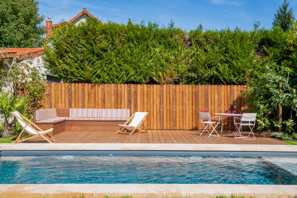 Inspiration pour une piscine design rectangle avec une terrasse en bois.