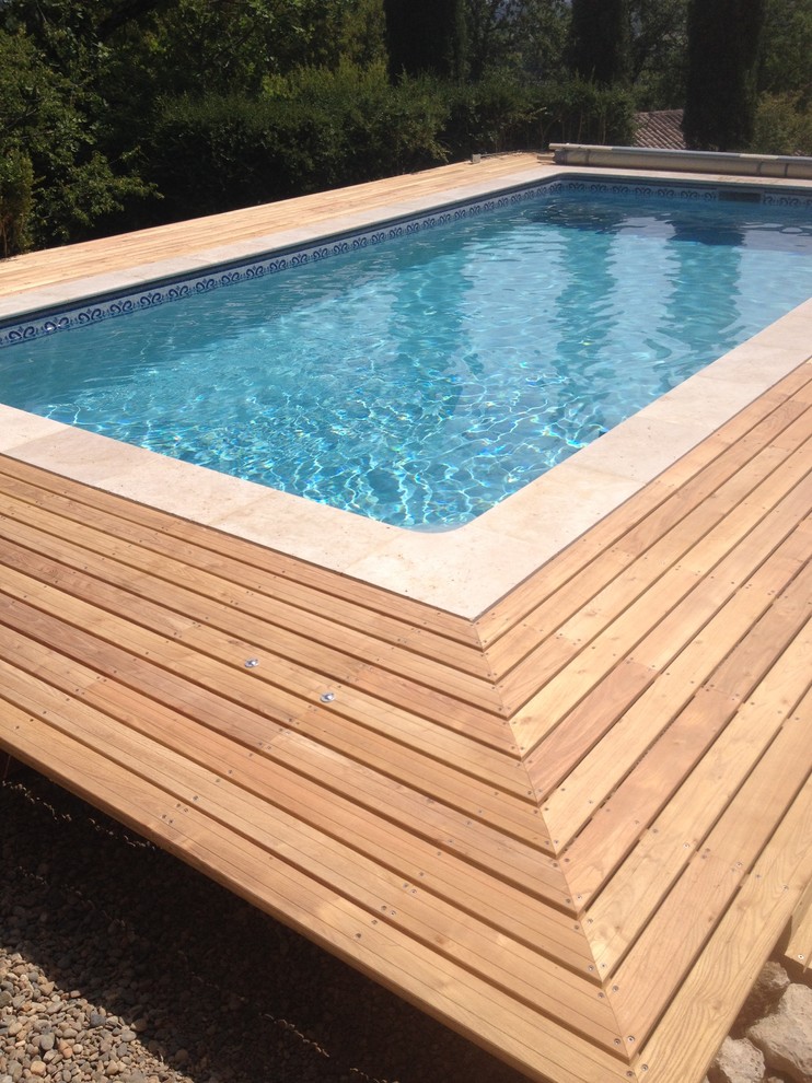 Idée de décoration pour une petite piscine hors-sol minimaliste rectangle avec une terrasse en bois.