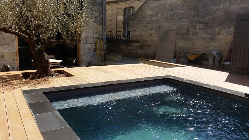 Kleiner Mediterraner Pool hinter dem Haus in rechteckiger Form mit Dielen in Bordeaux