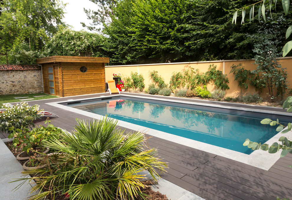 Idées déco pour un grand Abris de piscine et pool houses arrière contemporain rectangle avec une terrasse en bois.