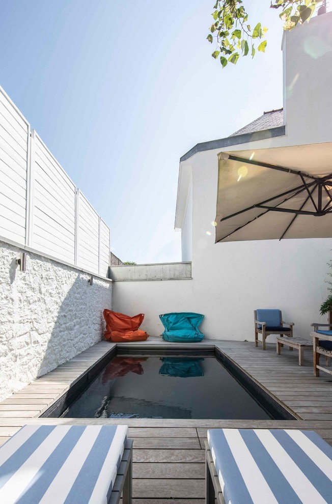 Imagen de piscina contemporánea pequeña rectangular en patio con entablado