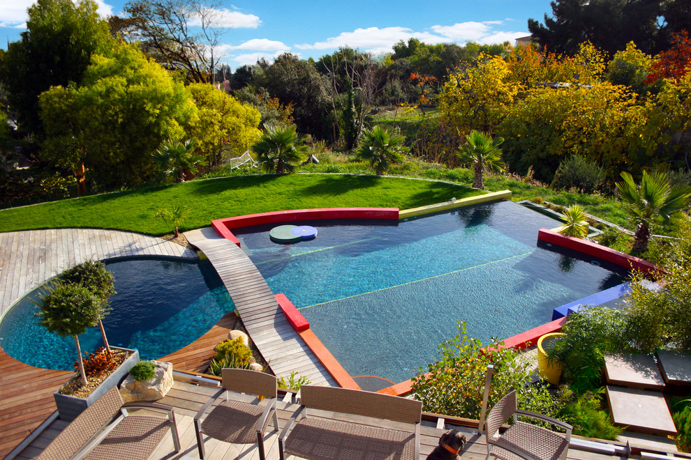Contemporary custom shaped swimming pool in Bordeaux with decking.