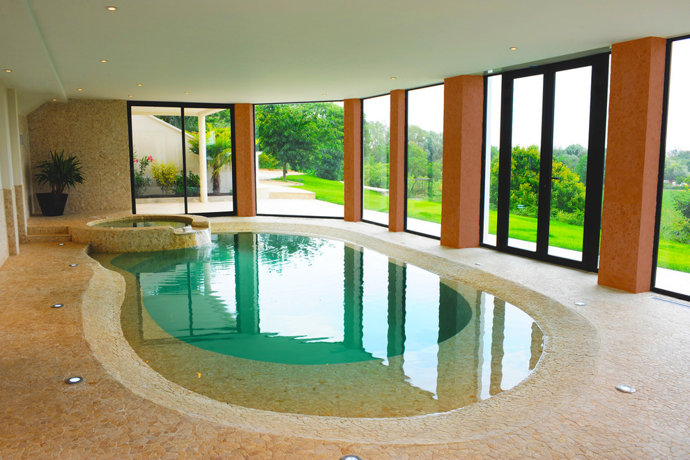 Idée de décoration pour une piscine intérieure méditerranéenne en forme de haricot avec un bain bouillonnant.