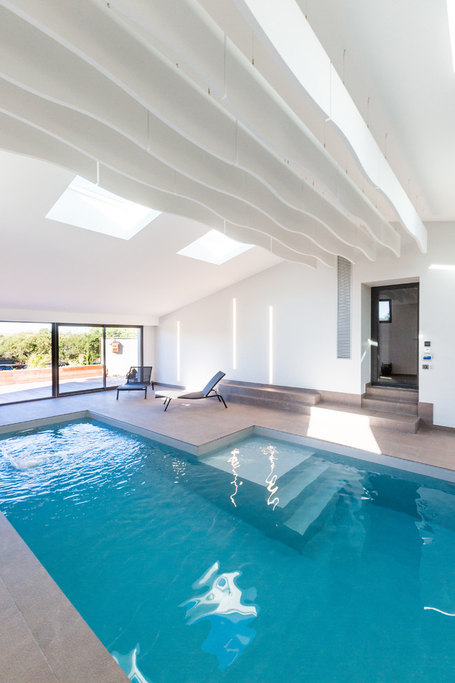 На фото: бассейн произвольной формы в доме в современном стиле
