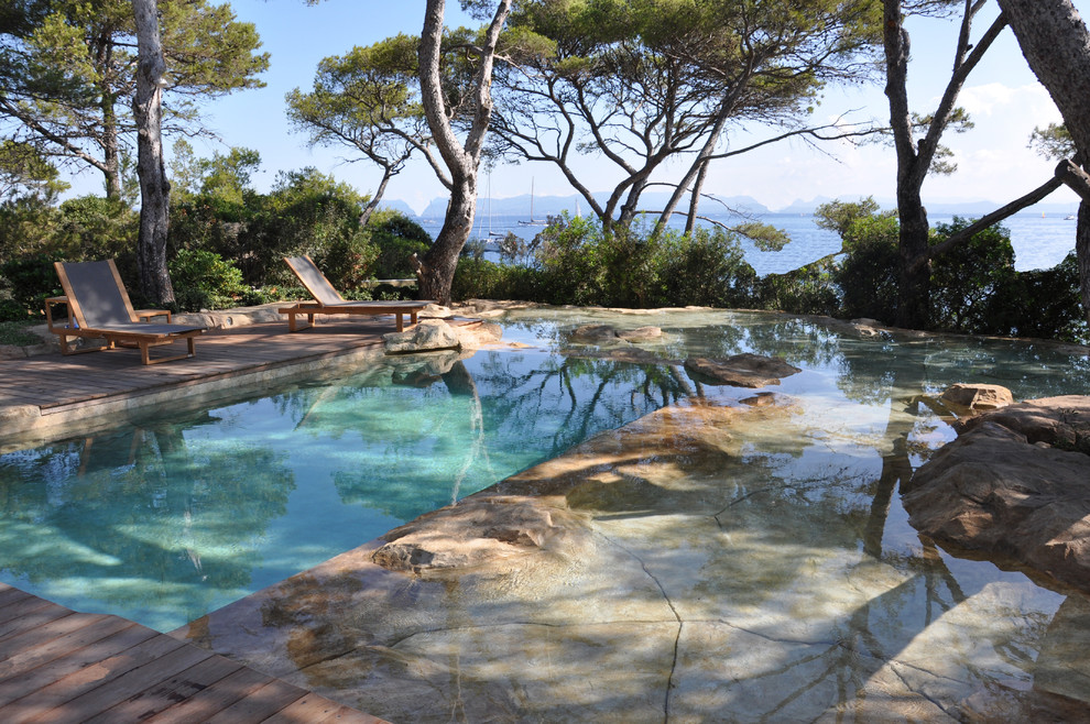 Photo of a large mediterranean custom shaped infinity swimming pool in Marseille with decking.