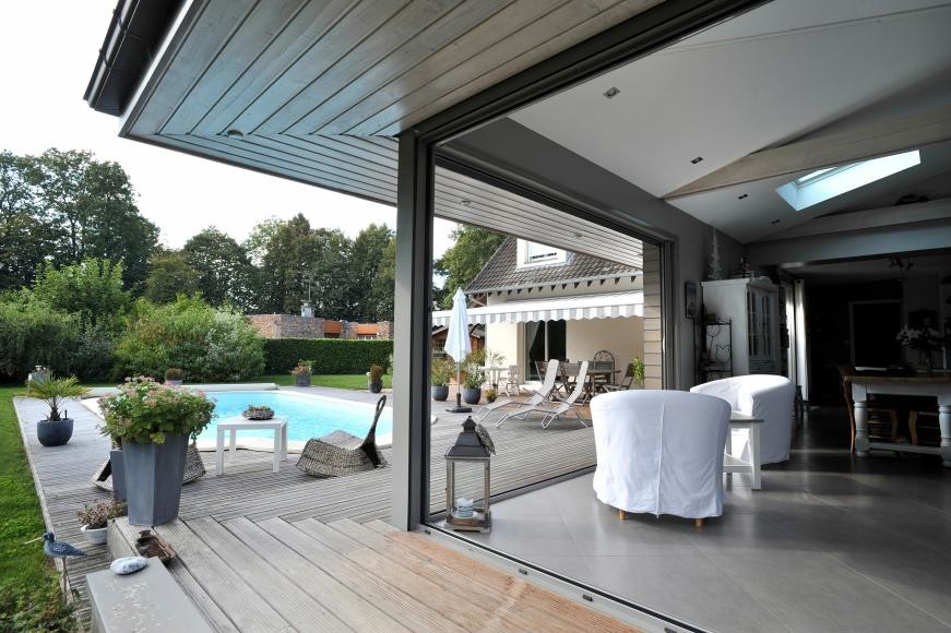 Inspiration pour une piscine arrière design de taille moyenne et rectangle avec une terrasse en bois.