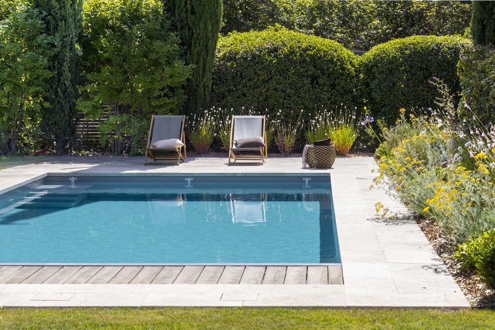 Ejemplo de piscina alargada mediterránea rectangular con adoquines de piedra natural