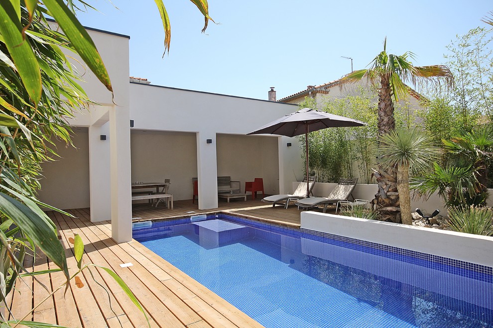 Immagine di una piscina monocorsia mediterranea rettangolare di medie dimensioni e dietro casa con pedane