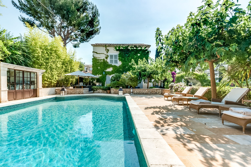Imagen de piscina alargada clásica grande rectangular en patio con losas de hormigón