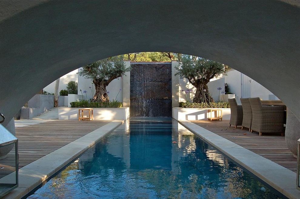 Идея дизайна: большой спортивный, прямоугольный бассейн на заднем дворе в современном стиле с фонтаном и настилом