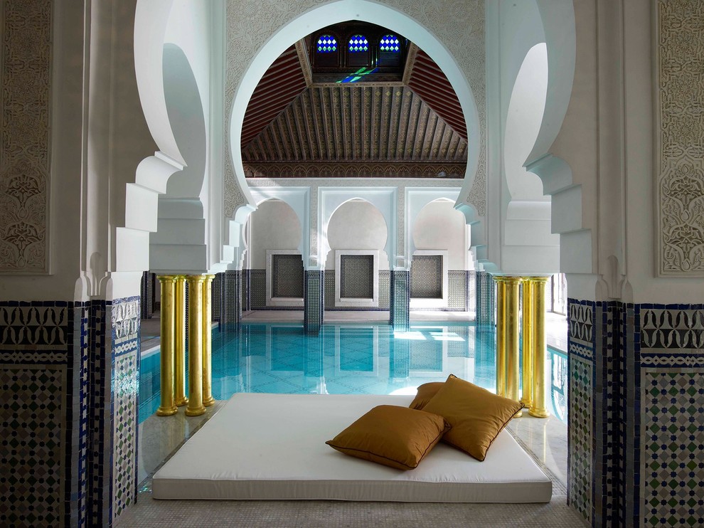 Immagine di una piscina coperta mediterranea rettangolare con piastrelle