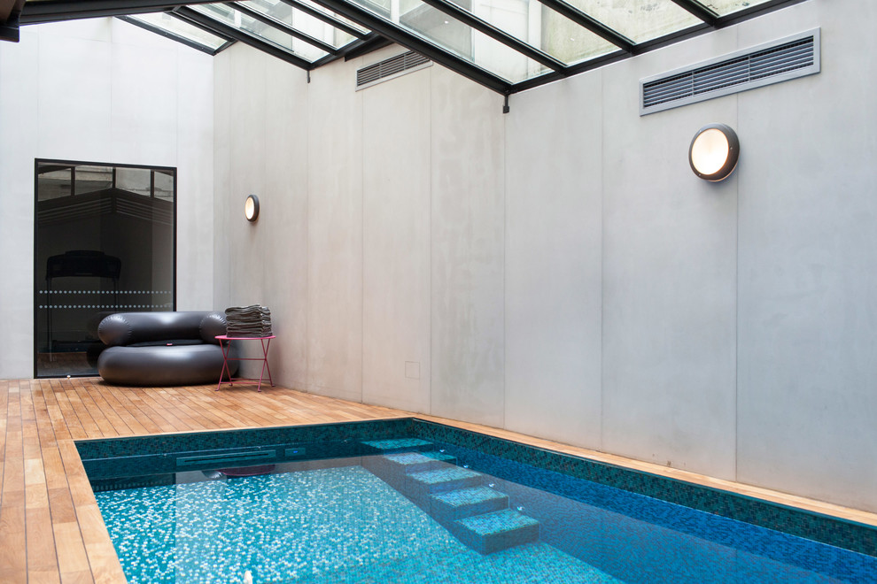 На фото: бассейн в современном стиле с покрытием из бетонных плит с