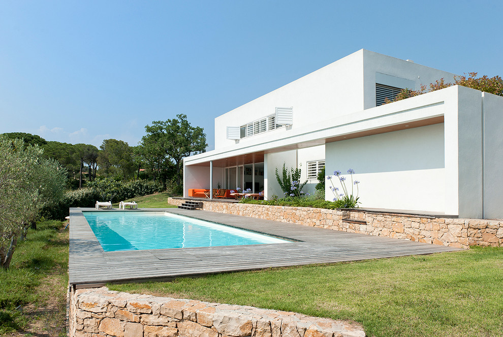 Свежая идея для дизайна: прямоугольный, спортивный бассейн среднего размера на заднем дворе в средиземноморском стиле с настилом - отличное фото интерьера