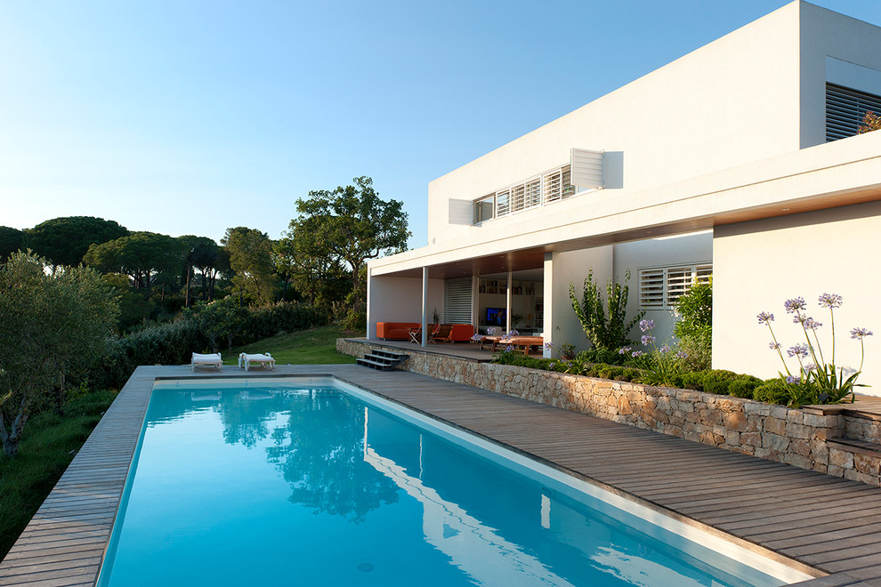 Imagen de piscina alargada mediterránea de tamaño medio rectangular en patio trasero con entablado