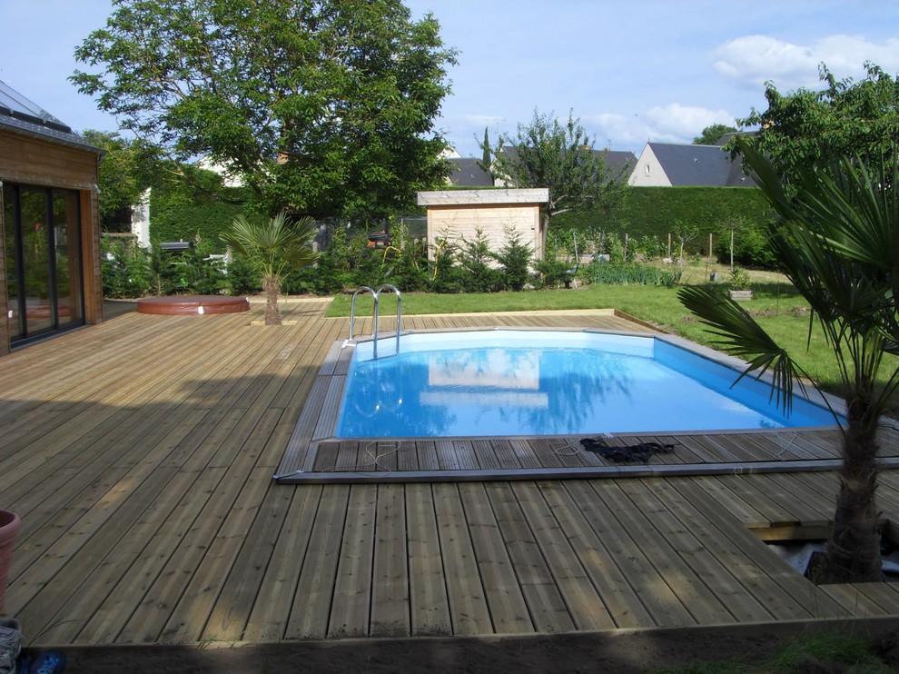 Ejemplo de piscina contemporánea rectangular en patio trasero con entablado