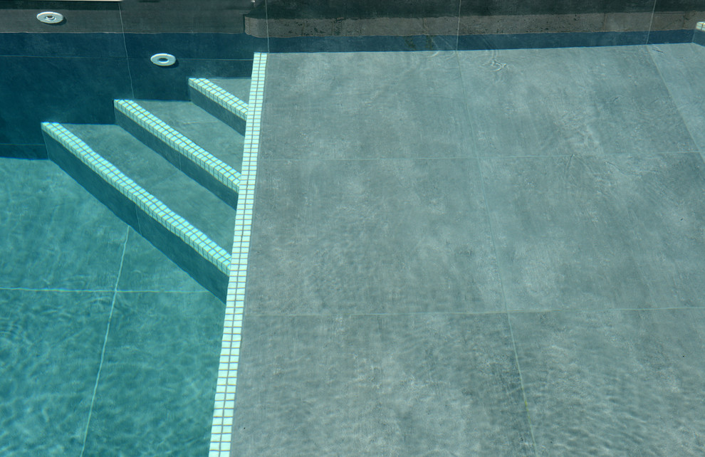 Cette photo montre un grand couloir de nage tendance en L avec une cour et du carrelage.
