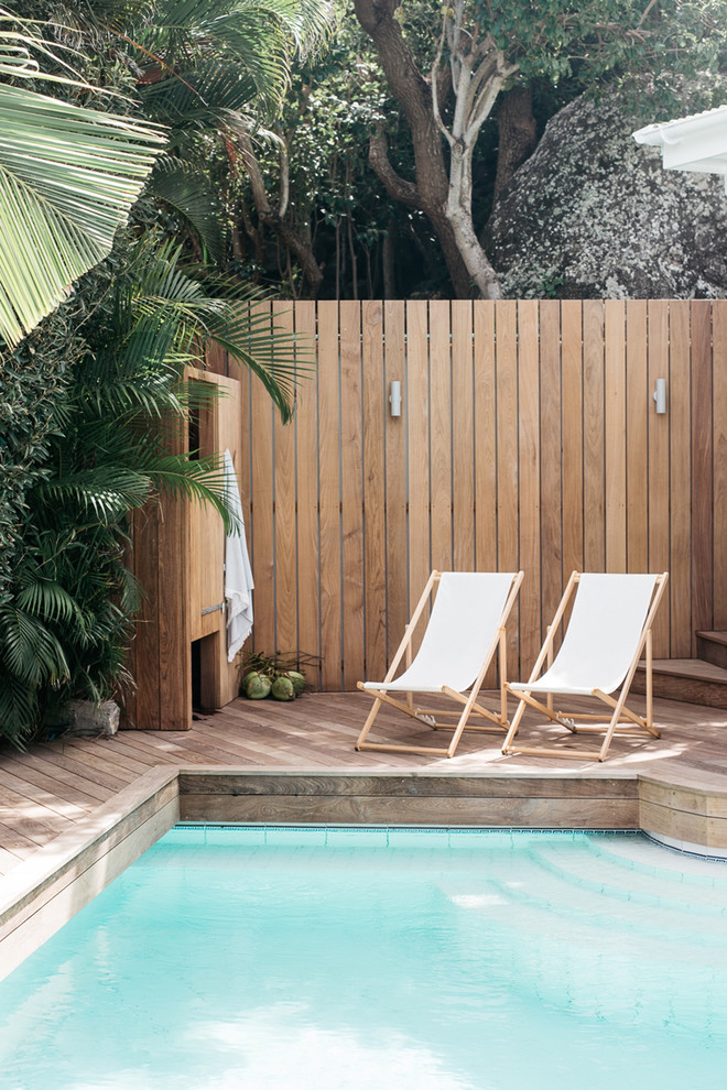 Exemple d'une piscine bord de mer avec une terrasse en bois.