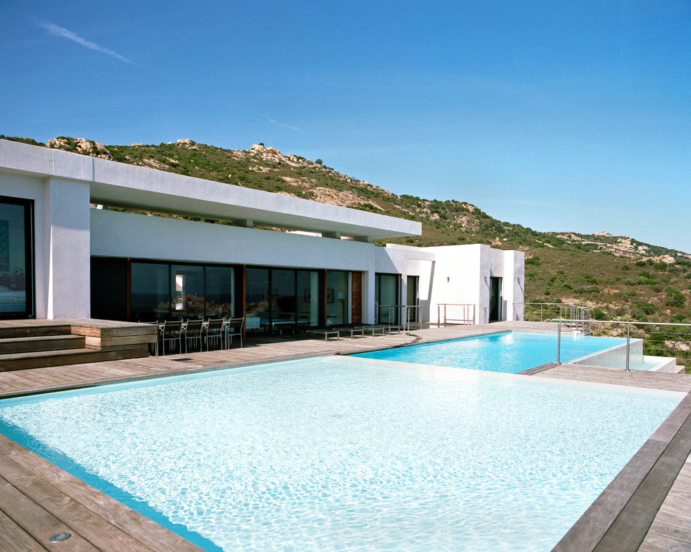 Diseño de piscina contemporánea grande a medida en patio trasero con entablado