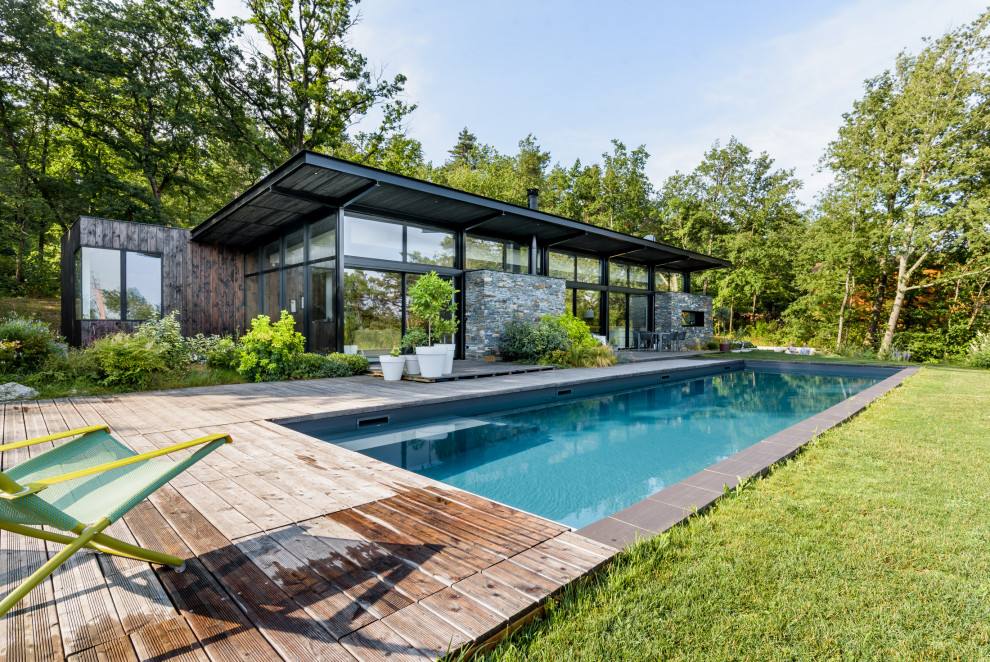 Свежая идея для дизайна: прямоугольный бассейн на заднем дворе в современном стиле с настилом - отличное фото интерьера
