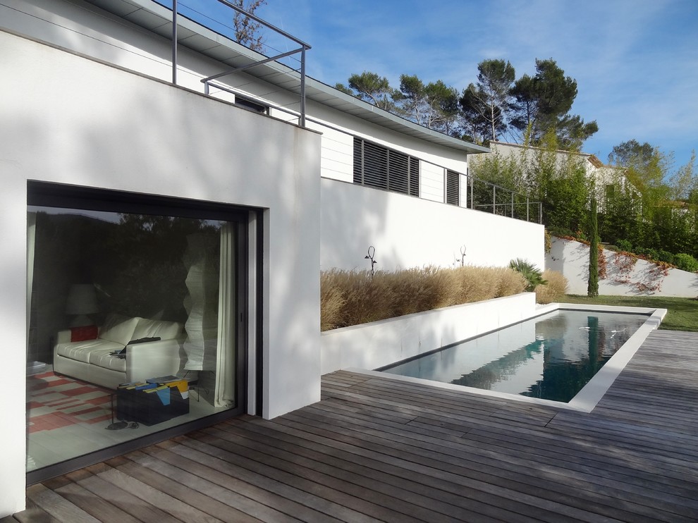 Immagine di una piscina minimal rettangolare di medie dimensioni e dietro casa con pedane