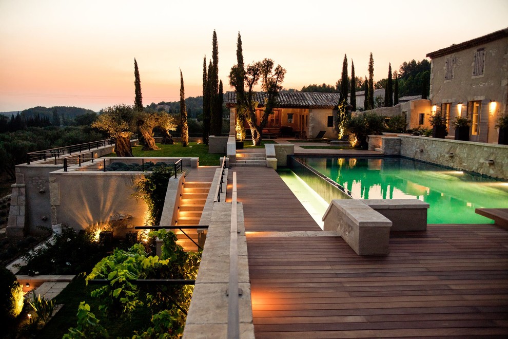 Idées déco pour une très grande piscine contemporaine rectangle avec un point d'eau et une terrasse en bois.