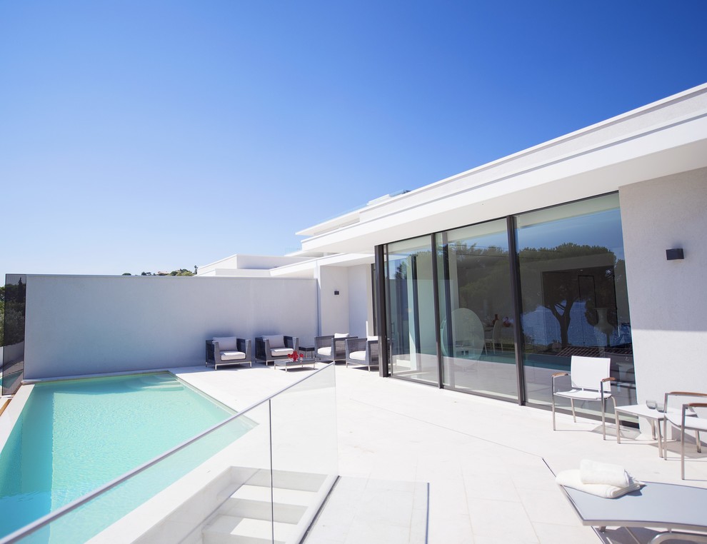 Large contemporary back custom shaped swimming pool in Nice with tiled flooring.