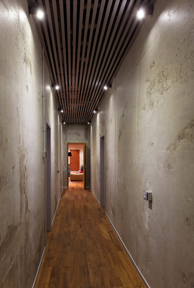 На фото: подземный, большой подвал в современном стиле с паркетным полом среднего тона, серыми стенами и коричневым полом с