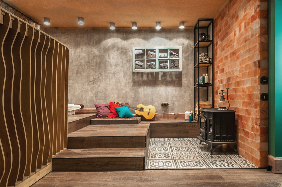 Idée de décoration pour une petite salle de séjour bohème avec un mur gris, un sol en vinyl et un poêle à bois.