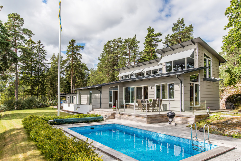 Mittelgroßes Modernes Sportbecken hinter dem Haus in rechteckiger Form mit Betonboden in Stockholm
